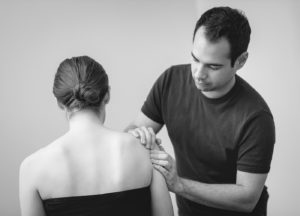 Sports physiotherapist treating a shoulder in Cambridge