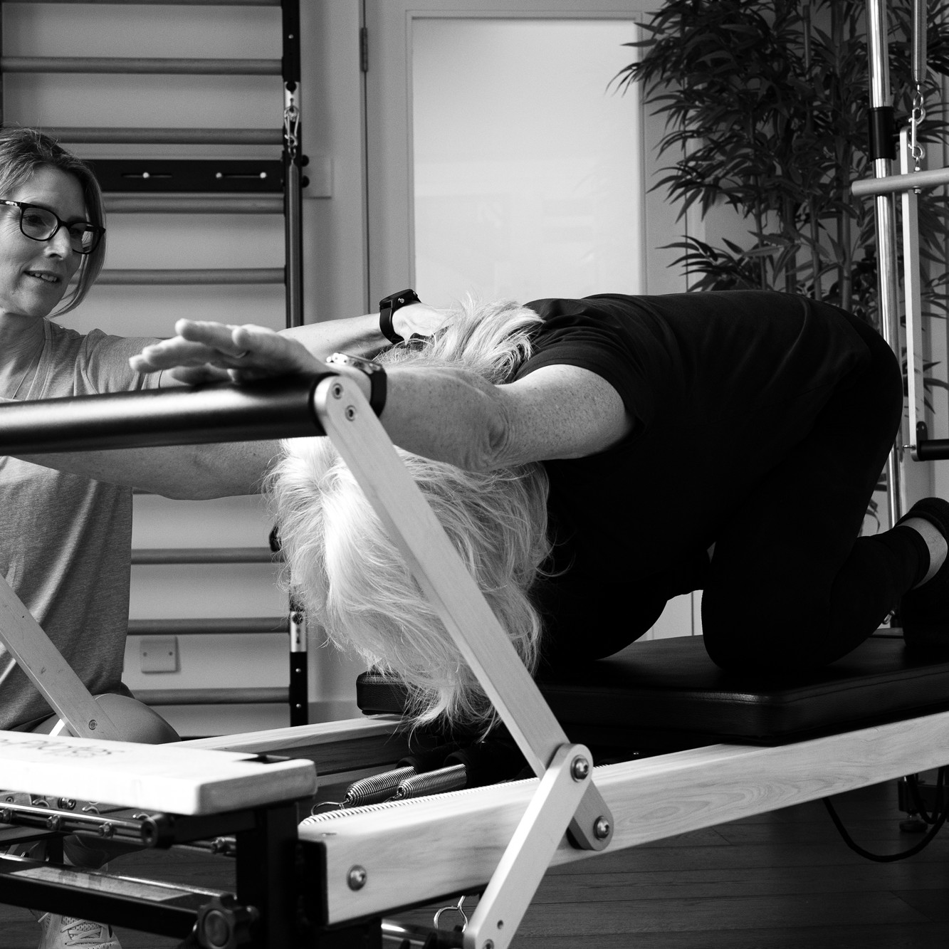 teaching pilates on a reformer to help a older adult with menopause symptoms